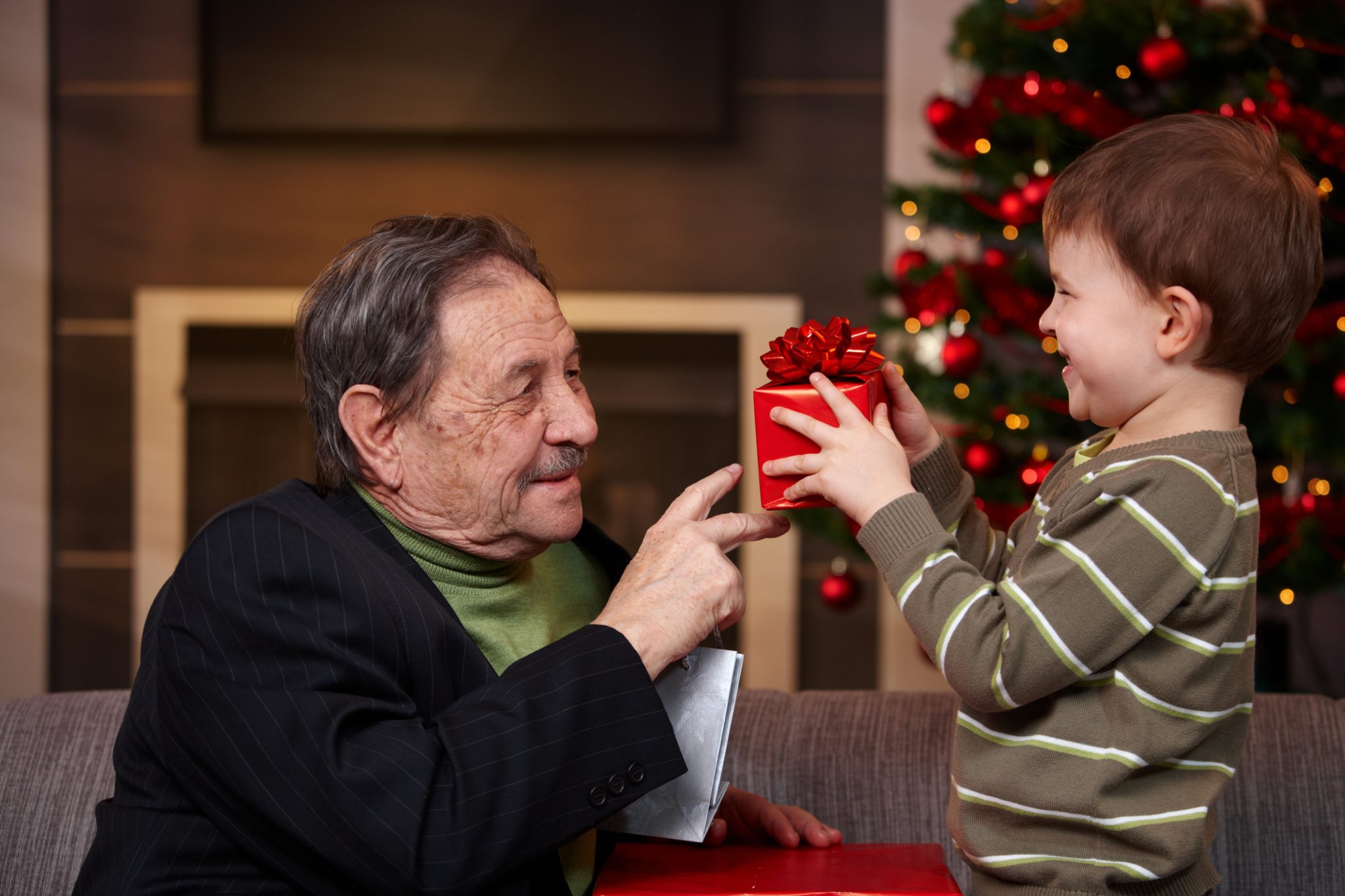 Grandchild giving present to grandfather on Christmas