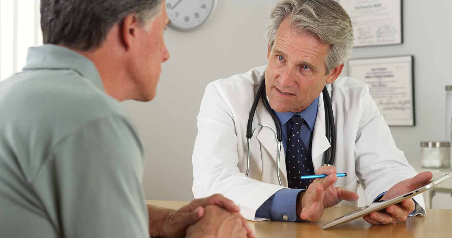 Coverage cancer care man talking to doctor