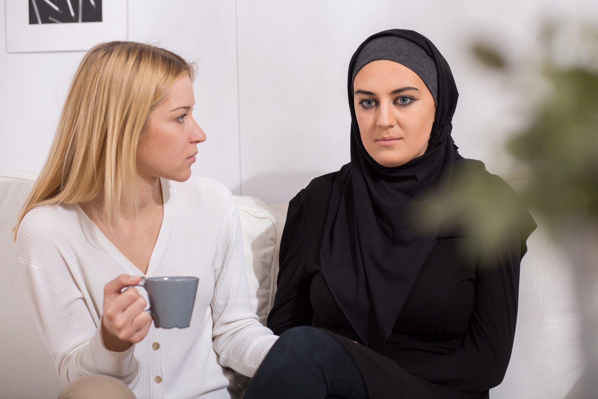 Scared blond woman and her worried muslim friend 2048 x 1365