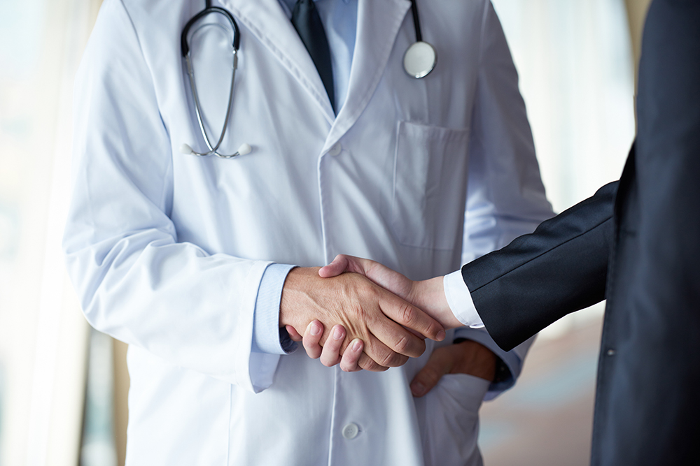 doctor shaking hands with man in suit 1000 x 667