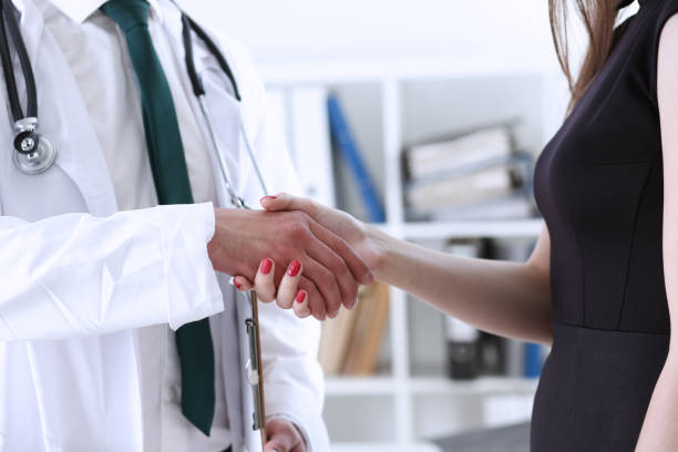 Doctor shaking hands with a female patient 612 x 408