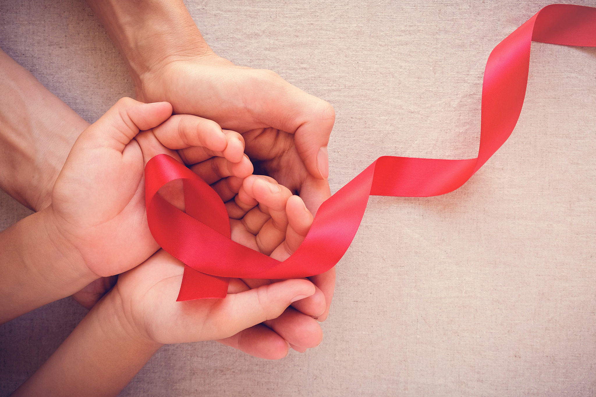 Hands holding a red AIDS ribbon 2048 x1365