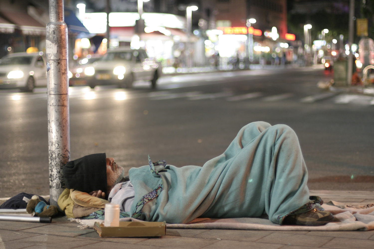 male homeless sleeping in a street 1500 x 1000