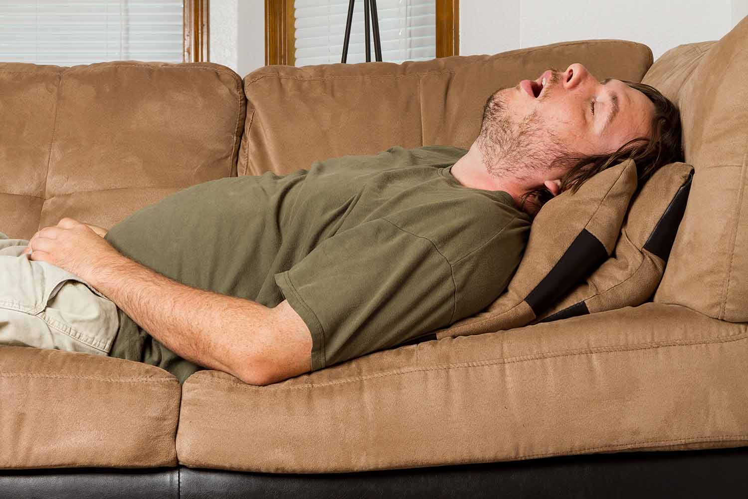 Man asleep on the couch with his mouth wide open snoring 1500 x 1000