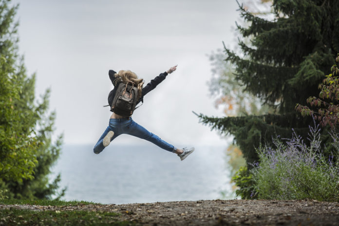 Woman jumping for joy near a lake 696 x 464