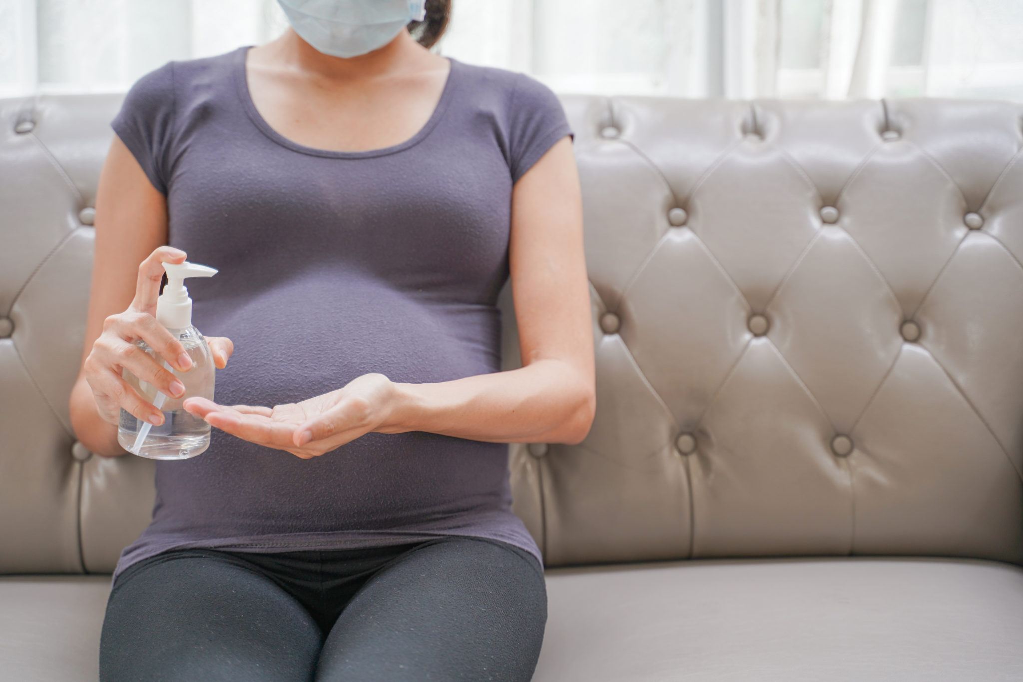pregnant woman with mask and hand sanitizer (family building)