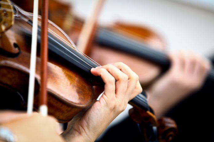 closeup of violins being played (music-physicians)